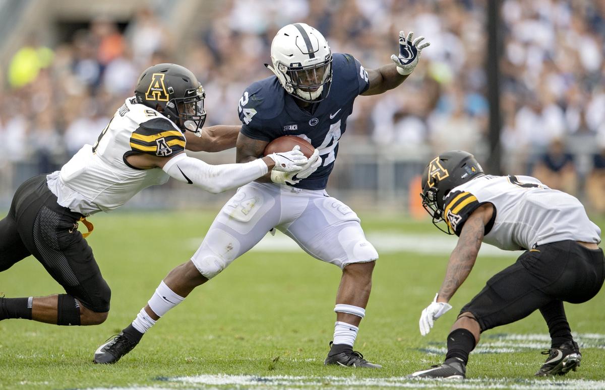 Appalachian State defensive back Austin Exford tries to stop Penn State running back Miles Sanders during the Saturday, Sept. 1, 2018 game at Beaver Stadium.