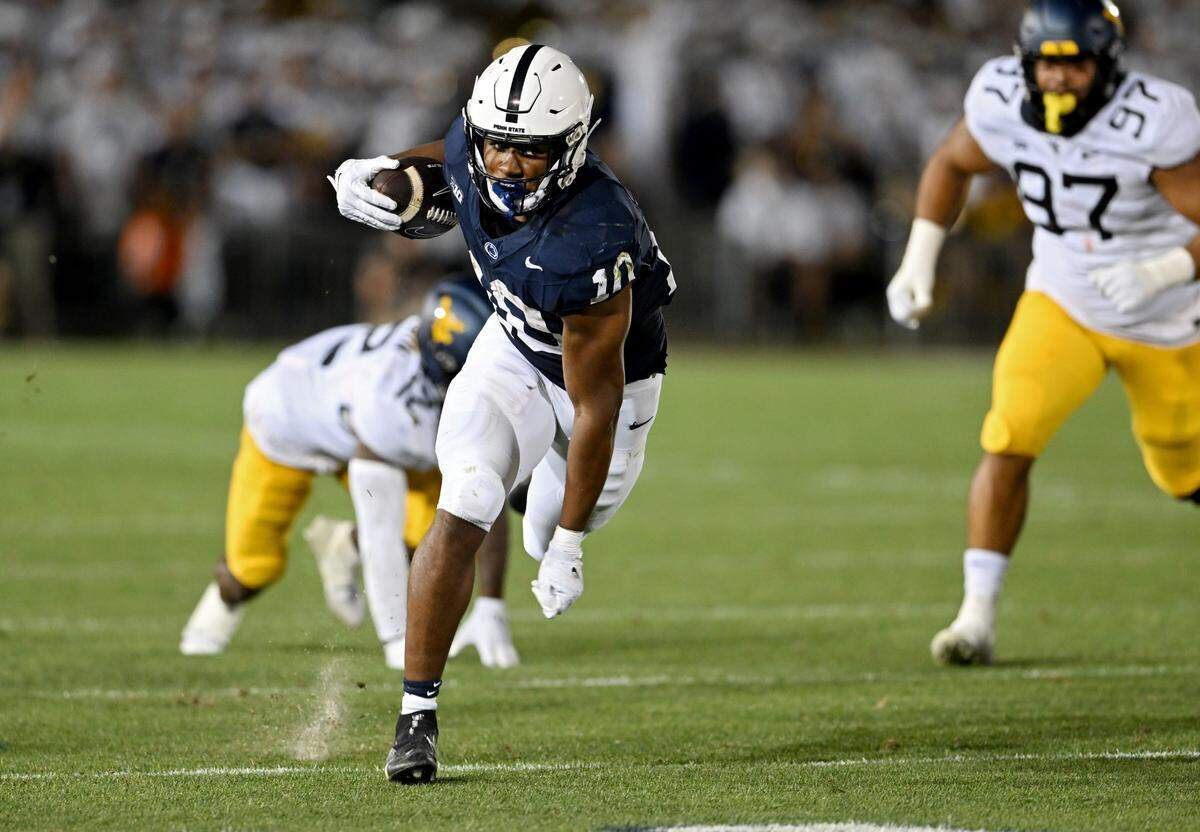Penn State running back Nick Singleton cuts down the field with the ball from West Virginia defenders during the game on Saturday, Sept. 2, 2023.