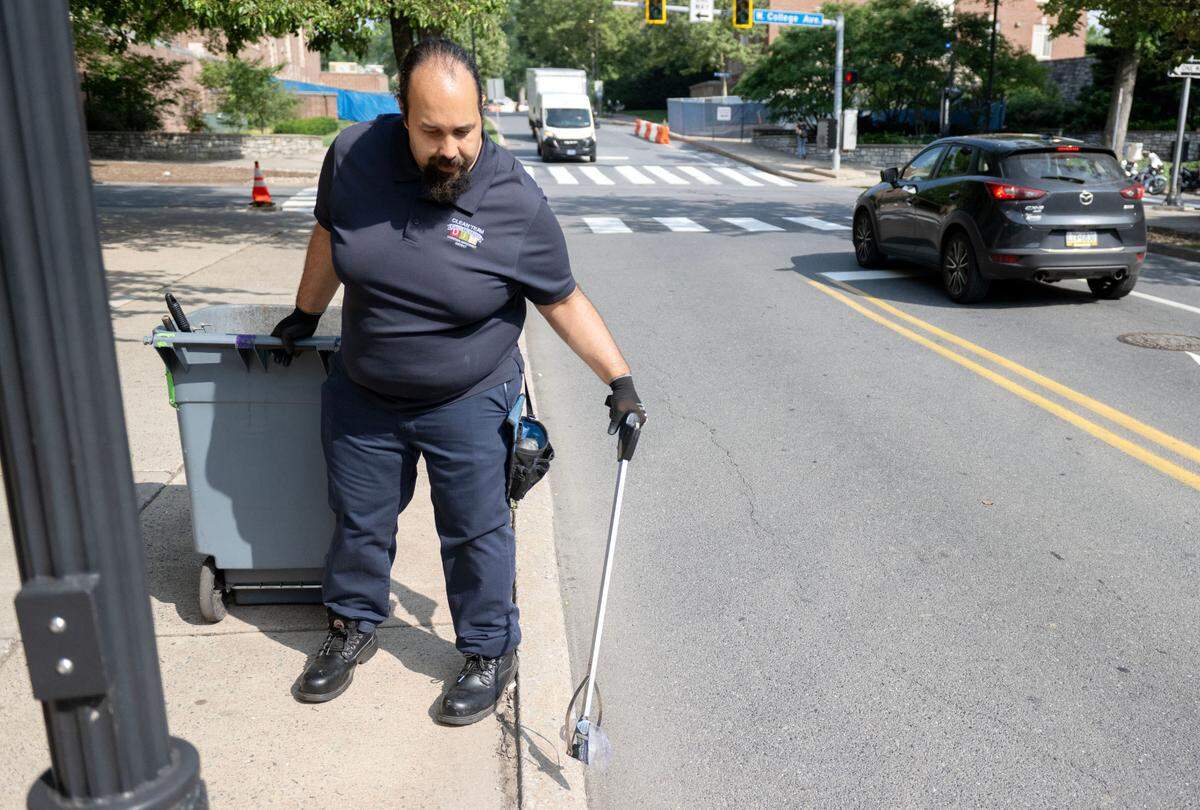 Damian Cabrera, the State College Downtown Improvement District Clean Team pathfinder, picks up trash along South Burrowes Street on Friday, July 11, 2025.