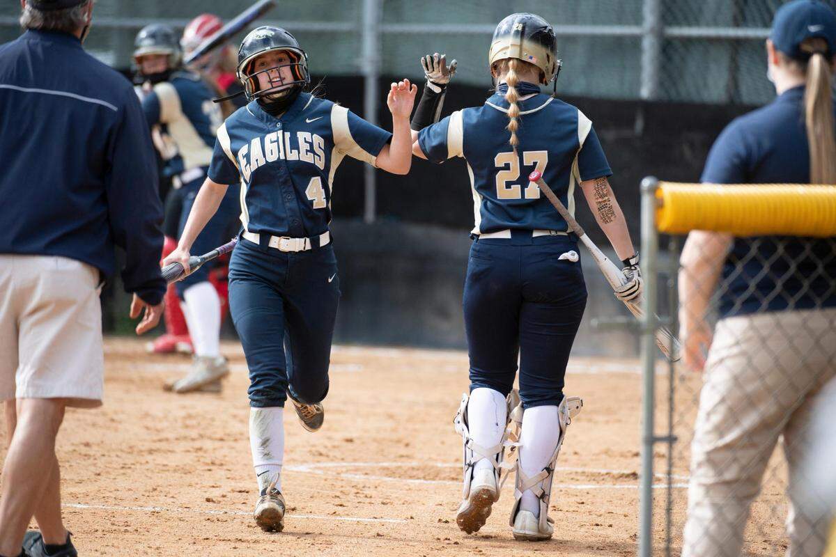 Bald Eagle’s Mara Hockenberry (4) celebrates with Maegan King (27) after scoring during Bald Eagle Area softball’s game against Central High School at the Milesburg youth baseball complex on Tuesday, April 13, 2021 in Milesburg, PA.