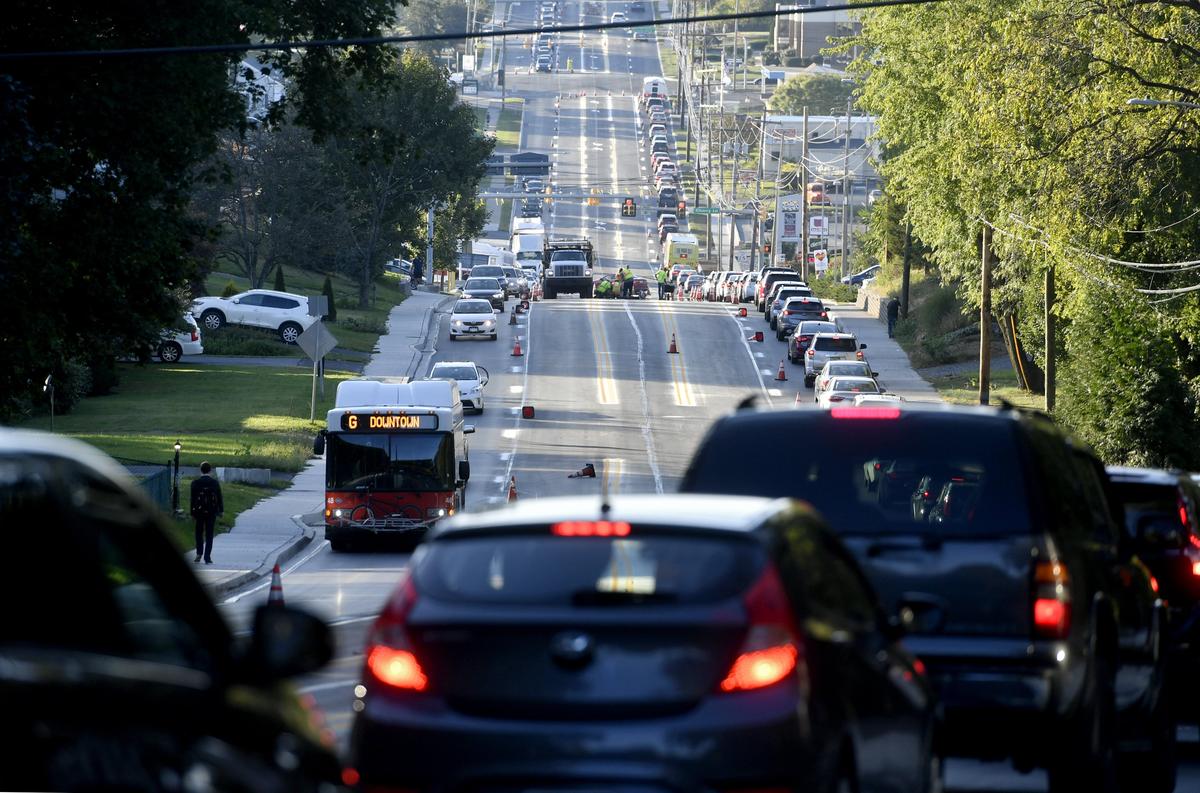 Traffic backs up as work crews paint the lines on the newly repaved section of North Atherton Street on Sept. 27.