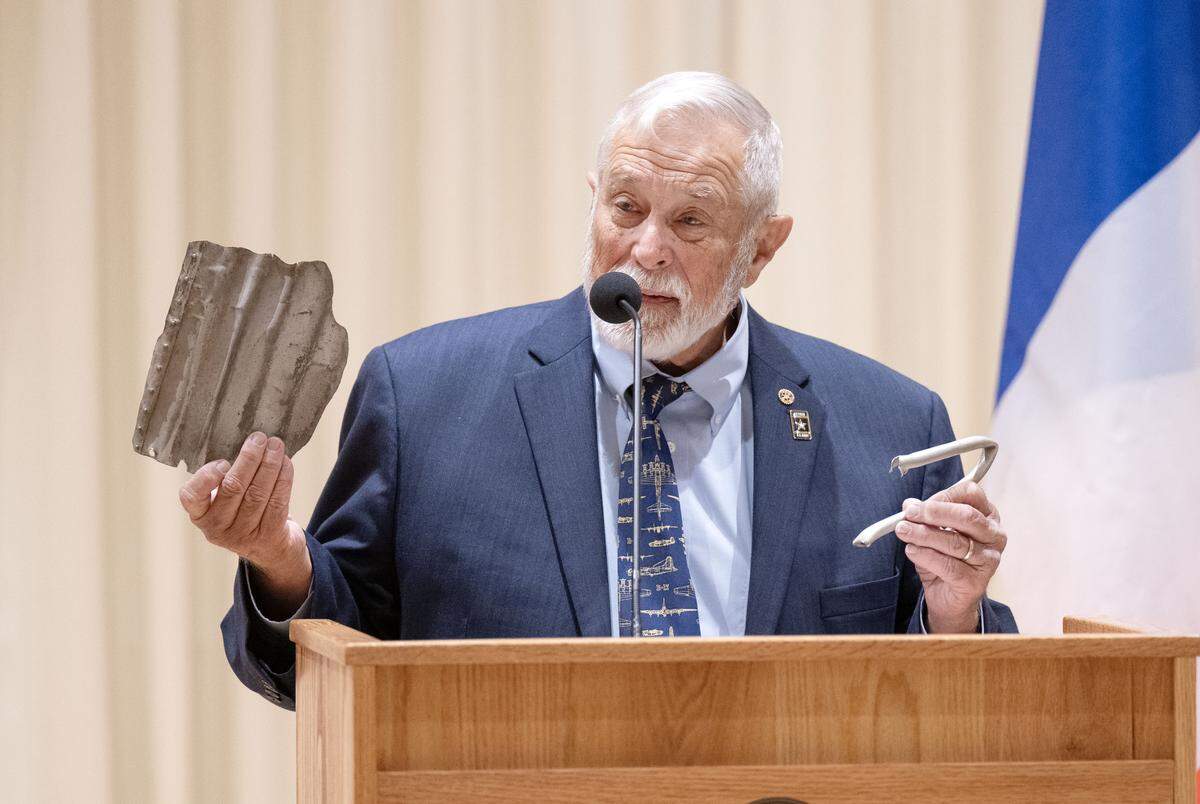 Charles Dalgleish talks about his World War II veteran father John Dalgleish saving pieces of metal from a consolidated B-24 Liberator bomber during a celebration for John F. Homan at Foxdale Village on Wednesday, Dec. 10, 2025. Homan, who was a bomber pilot with Dalgleish, was presented the French Legion of Honor.