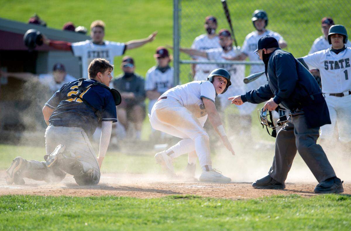 Cedar Cliff’s Gabe Kocher and State College’s Ethan Schimony look at the umpire for the call at the plate during the game against Cedar Cliff on April 20. Schimony was called out on the play.