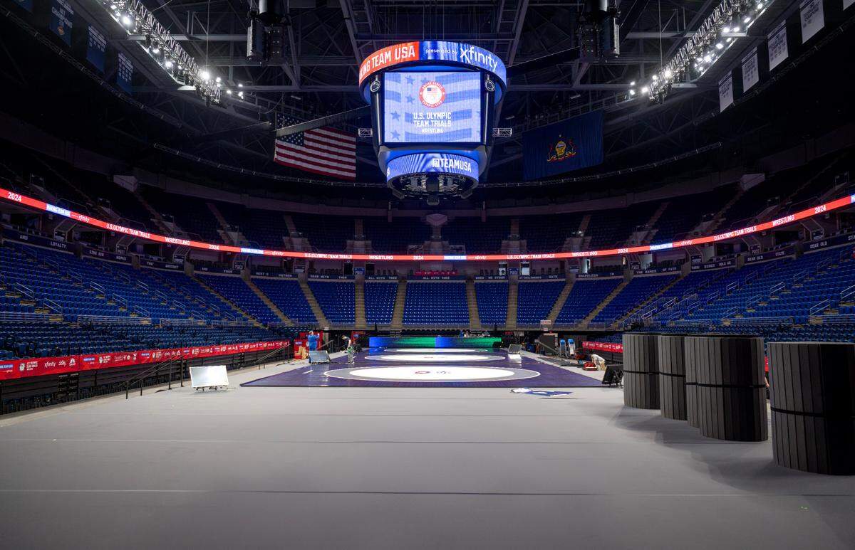 A stage with four mats is being set up for the U.S. Olympic Team Trials for wrestling at the Bryce Jordan Center.