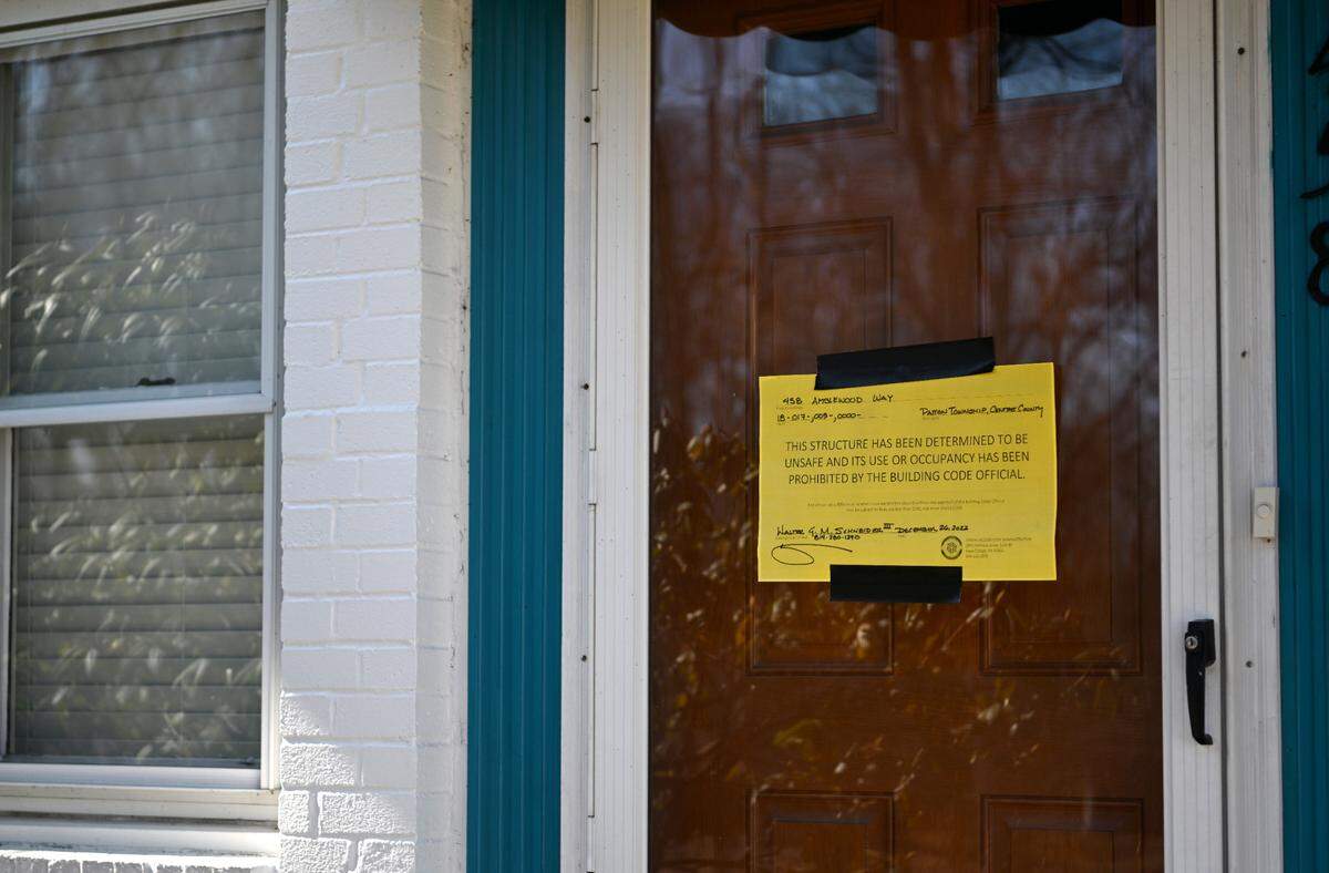 Signs hang on the doors of several of the homes on Amblewood Way where residents are still not allowed to occupy their homes due to the sinkhole that happened in late December. 