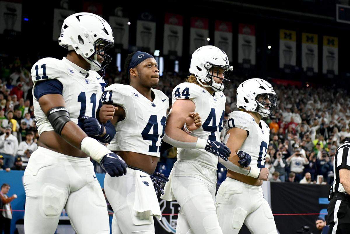 Penn State captains Abdul Carter, Kobe King, Tyler Warren and Dominic DeLuca walk onto the field with arms linked before the Big Ten Championship game against Oregon at Lucas Oil Stadium on Saturday, Dec. 7, 2024.