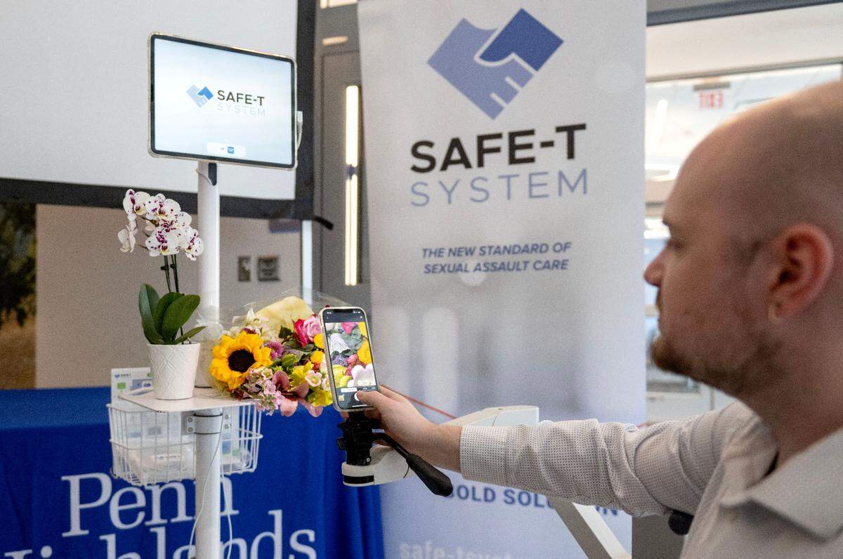 Ian Spears shows how the Sexual Assault Forensic Examination Telehealth (SAFE-T) System works by demonstration on a bouquet of flowers on Tuesday, May 27, 2025.