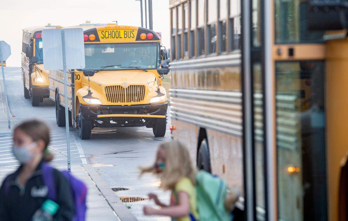 Students hop off the bus wearing masks excited for the first day of school at Wingate Elementary on Tuesday, Aug. 25, 2020.