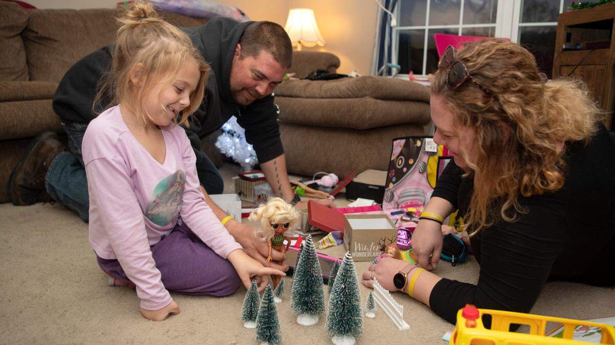 Kennedy Wilson, 6, plays with her parents, Nathan and Kimberly, in their Bellefonte home on Monday. The Wilson family will hold a fundraiser next month for Four Diamonds, which helped Kennedy while she was treated for cancer.