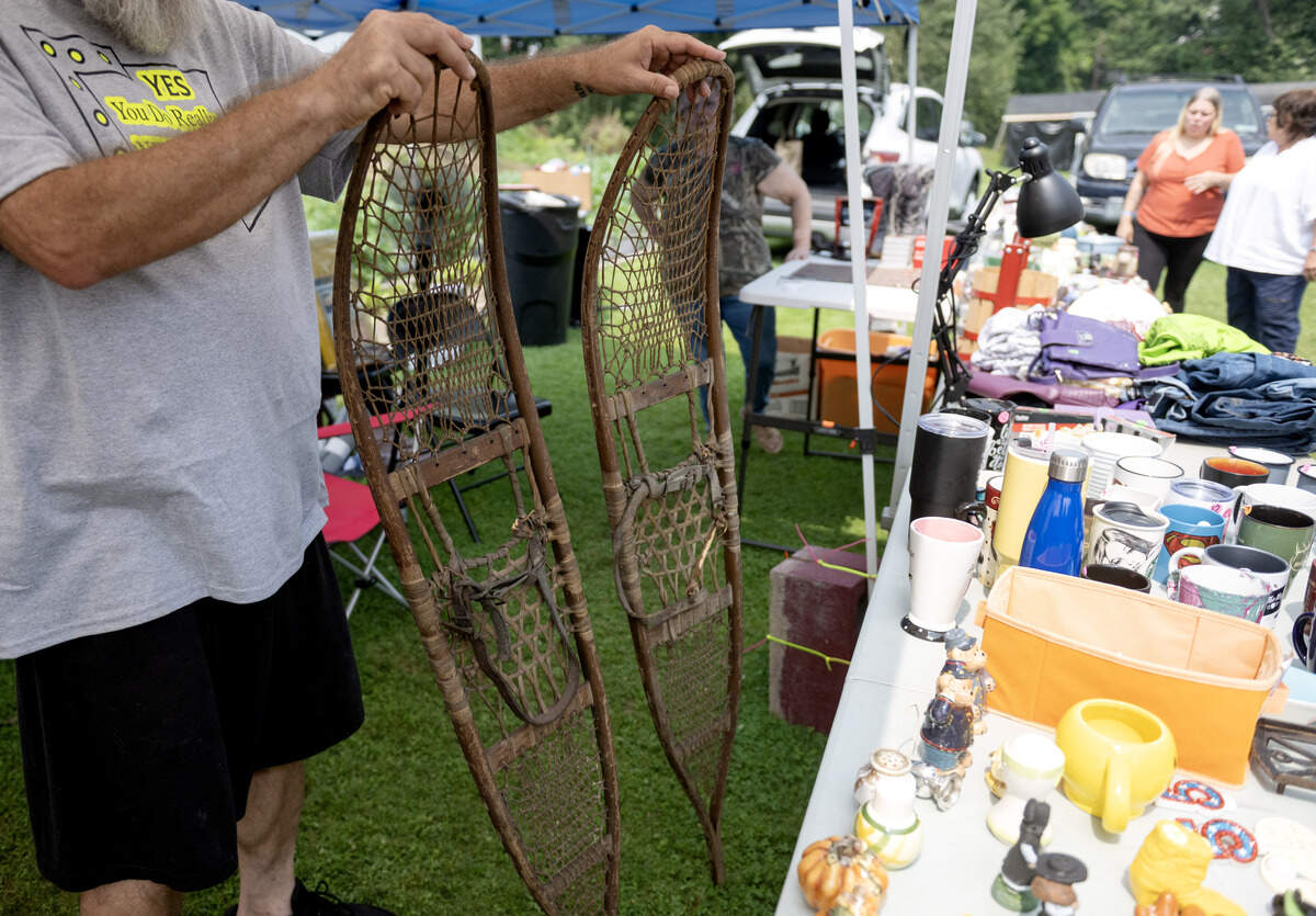 Cliff Cagle shows a pair of snow shoes from the 1940s for sale at his yard sale in Snow Shoe during the 100 Mile Yard Sale on Friday, July 17, 2026.