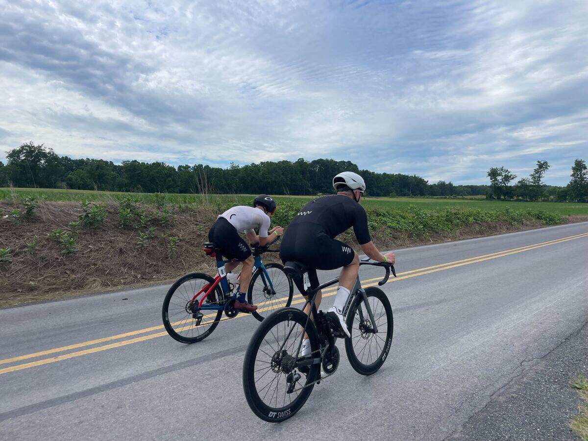 Dylan Sebek (left) and another cyclist pass by on Jacksonville Road on Sunday, June 14, 2026, during the Ironman 70.3 Pennsylvania Happy Valley North American Championship in Centre and Clinton counties.