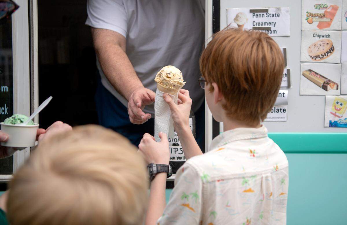 A youngster gets a cone of ice cream from the Classic Cones ice cream truck on Friday, June 3, 2022.