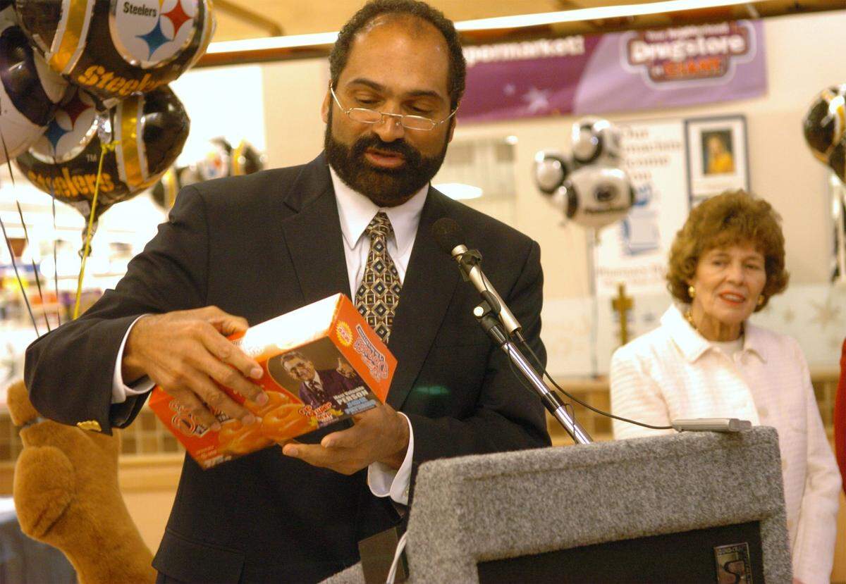 Sue Paterno looks on as Harris, holding a box of Super Donuts announces the Super MVP program honoring Penn State coach Joe Paterno during a press conference at the Northland Center Giant in 2007.