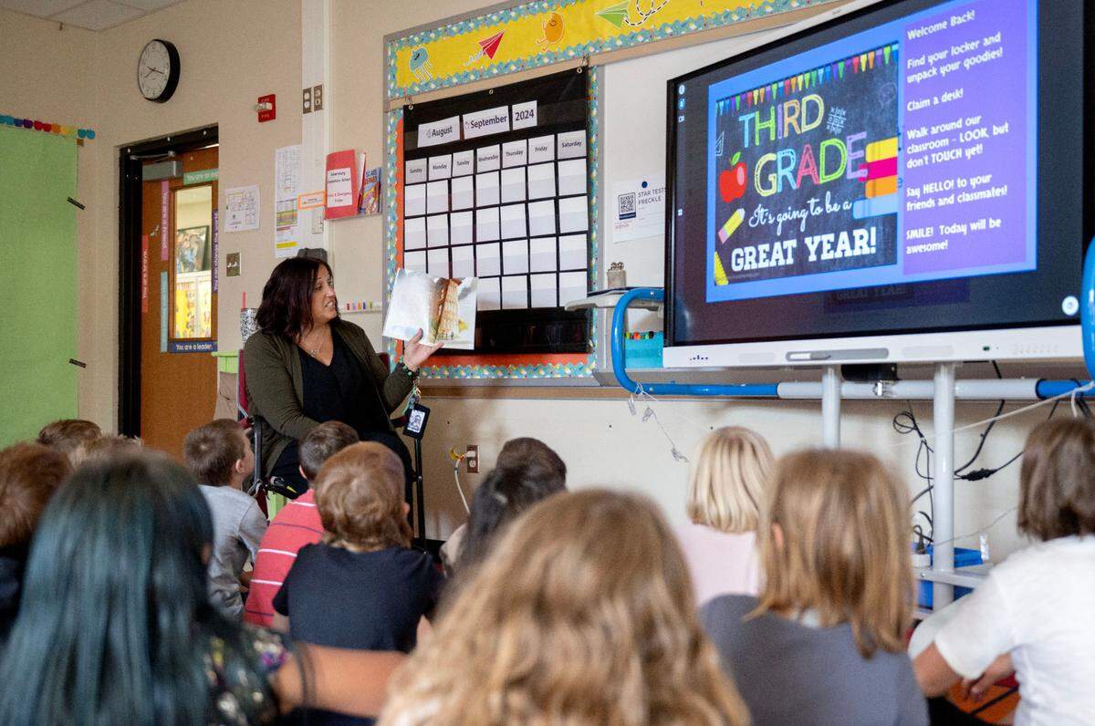 Shelley Feltenberger reads a book about the first day of school to her third grade class to welcome them to the school year at Miles Township Elementary on Tuesday, Aug. 27, 2024.  
