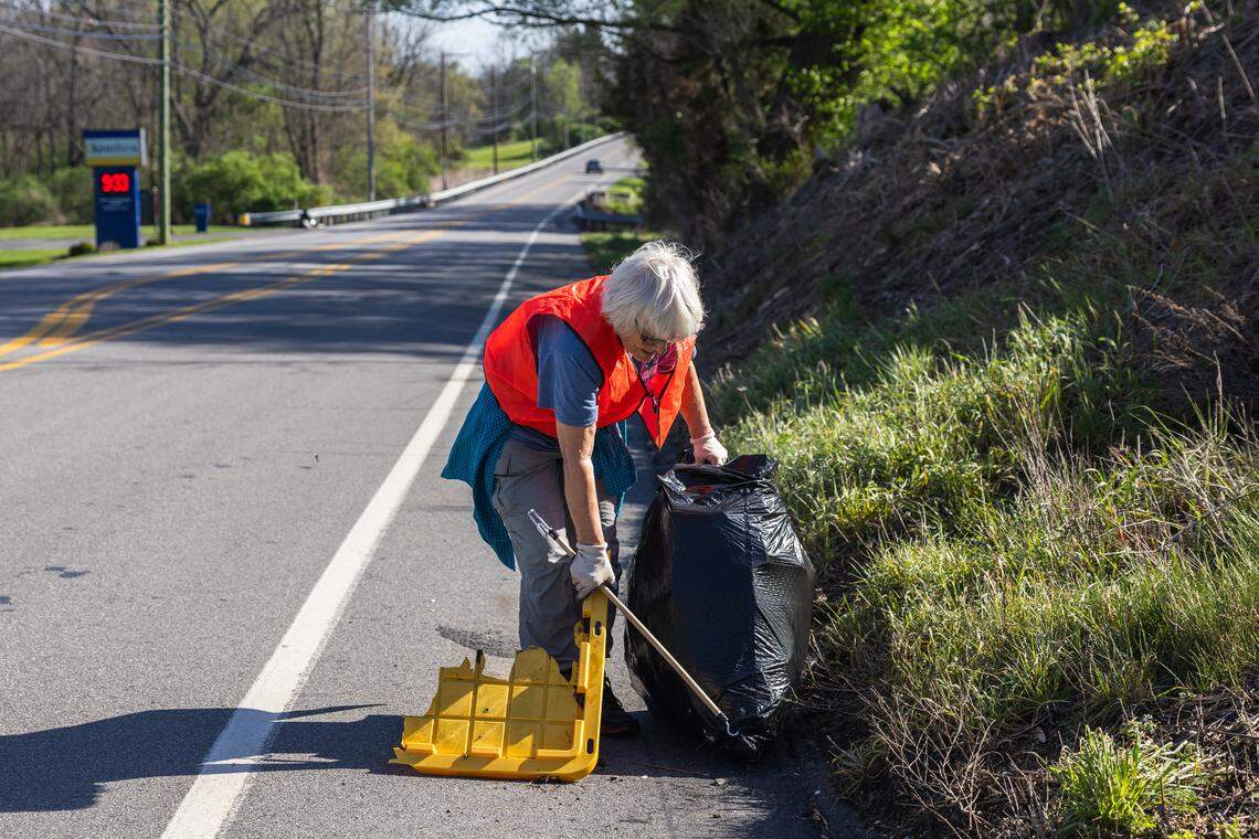 Volunteer Darlene Clark picks up trash in Pine Grove Mills, Pa., on Saturday, April 18, 2026. The ClearWater Conservancy organized volunteers across Centre County to clean up public green spaces.