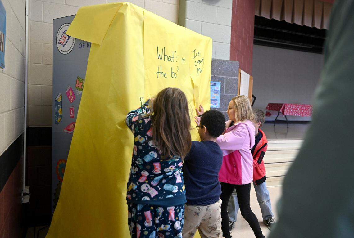 A group of students unwrap the The Golden Ticket to Literacy book vending machine at Centre Hall Elementary on Friday, Feb. 3, 2023.