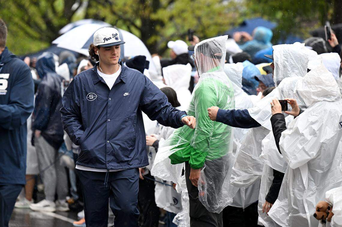Penn State quarterback Rocco Becht fist bumps fans as he walks to Beaver Stadium for the Blue-White Practice on Saturday, April 25, 2026.  