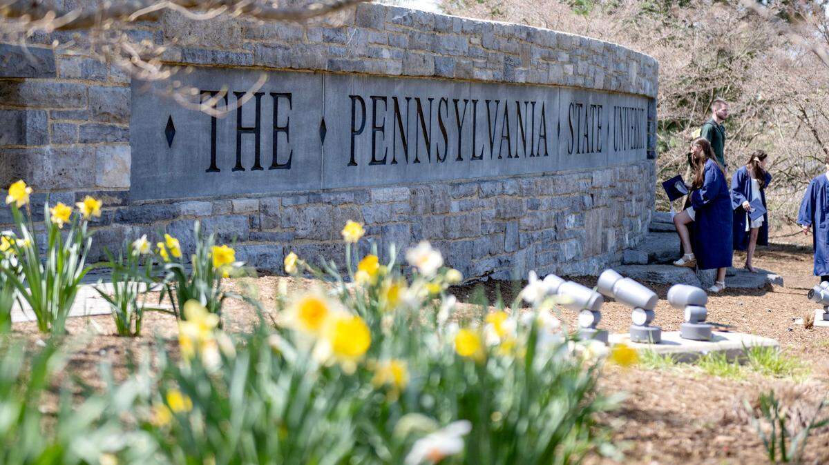 Soon-to-be graduates take photos at the Pennsylvania State University sign along Park Avenue on Wednesday, April 23, 2025.