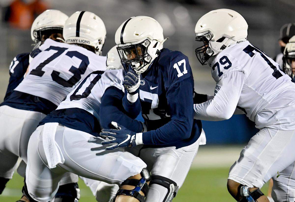 Defensive end Arnold Ebiketie pushes between offensive linemen during Penn State football practice on Friday, April 23, 2021 at Beaver Stadium.