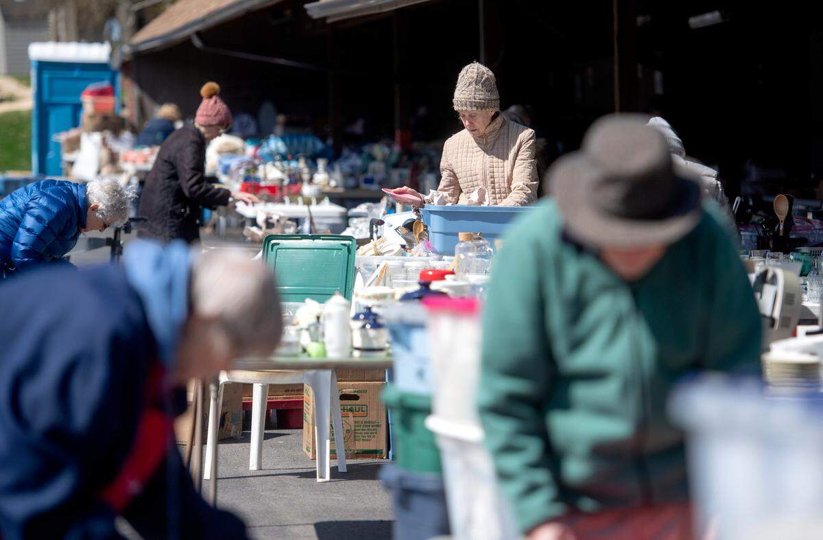 Residents of Foxdale Village help to set up the items for the annual yard sale on Thursday, April 28, 2022.