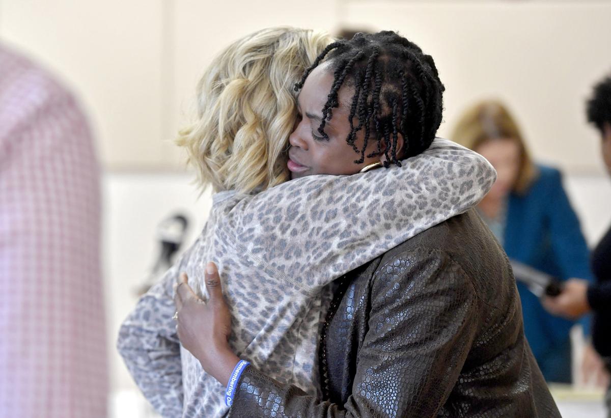 Iyun Osagie hugs a friend who was at the press conference announcing the filing of a lawsuit into the fatal shooting of her son Osaze.