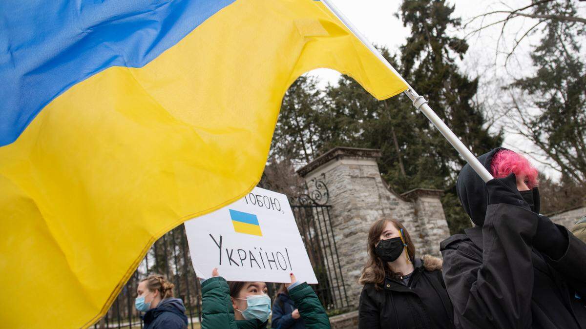 Ekaterina Luchkina holds a Ukrainian flag during a protest against the Russian invasion of Ukraine in front of the Allen Street Gates on Thursday in State College.