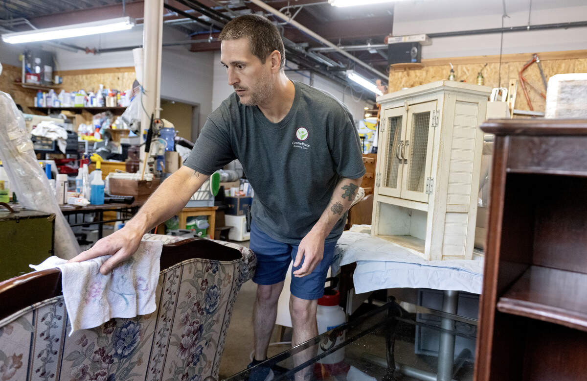 Tim Morris wipes down a donated sofa after spraying it with disinfectant at CentrePeace on Thursday, June 25, 2026