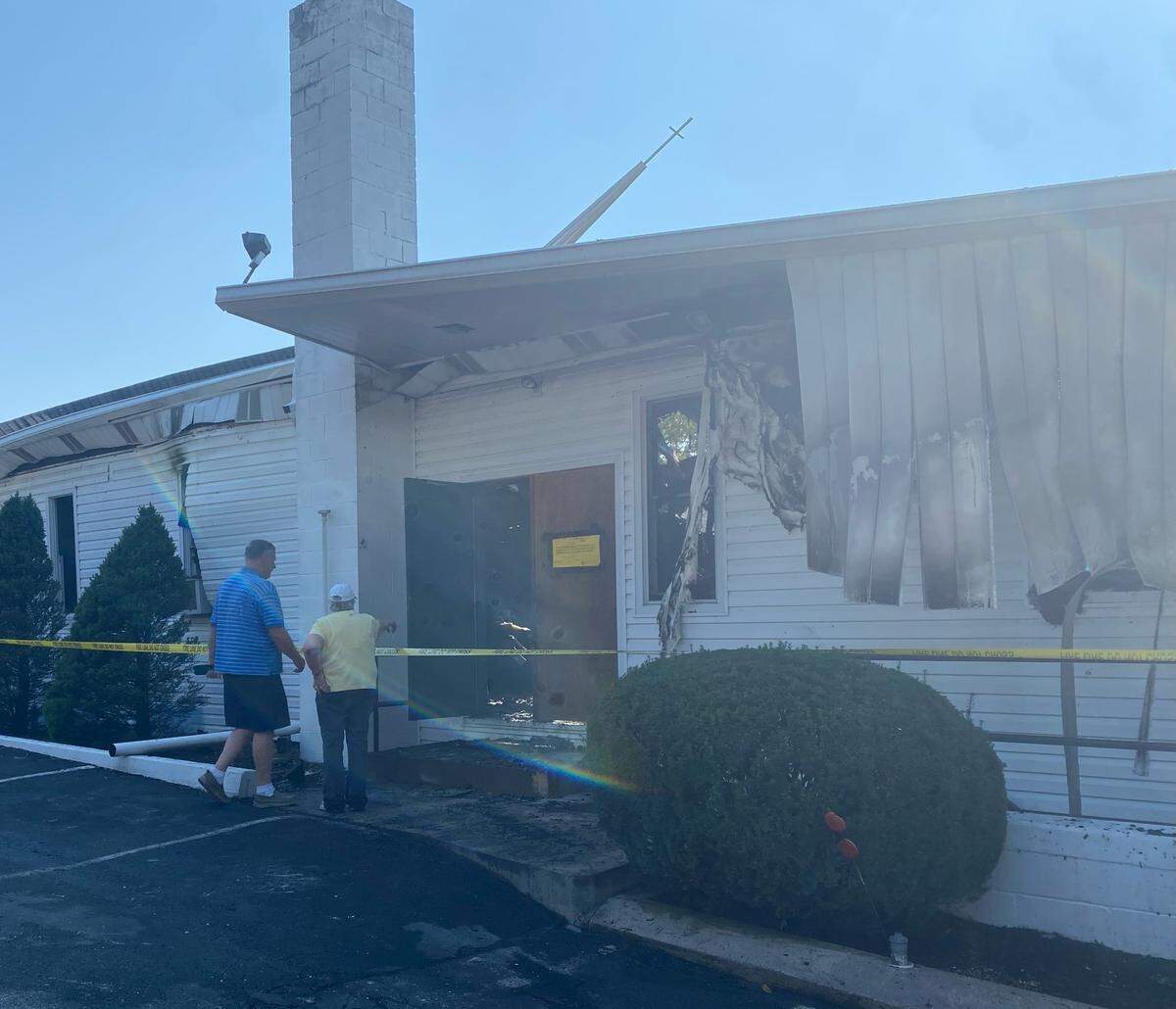 Congregants look at the damage in the sanctuary of Woodycrest United Methodist Church in Patton Township. The roof partially collapsed after a fire at the church early Saturday morning.
