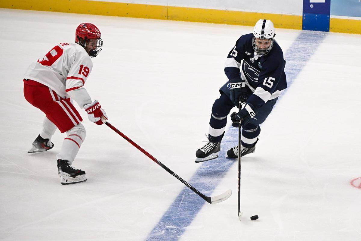 Apr 10, 2025; St. Louis, Missouri, UNITED STATES; Penn State Nittany Lions forward Charlie Cerrato (15) controls the puck while Boston University Terriers defenseman Jack Page (19) defends during the first period of the Frozen Four college ice hockey national semifinals at Enterprise Center. Mandatory Credit: Connor Hamilton-Imagn Images