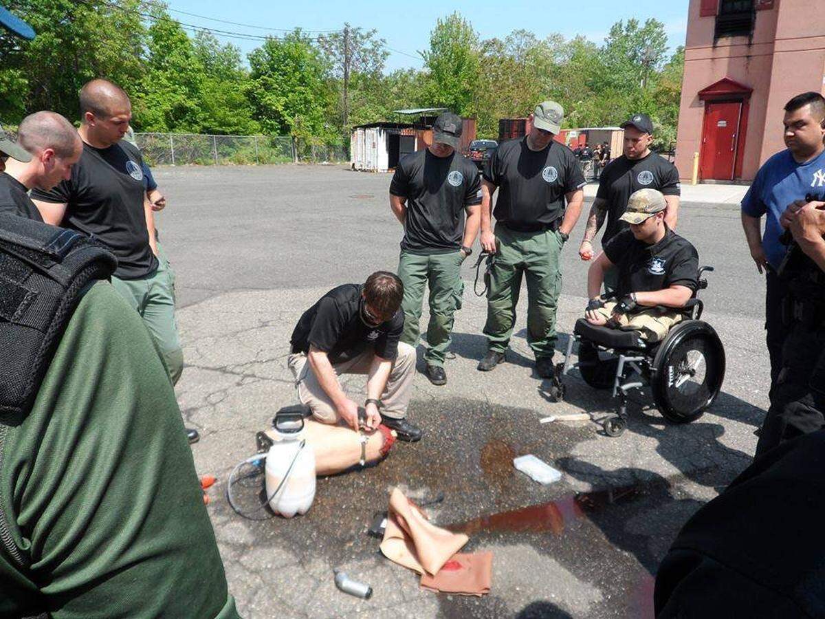 Adam Hartswick, at right in a wheelchair, teaches a tactical combat casualty care course for EMTs and firefighters in 2015.