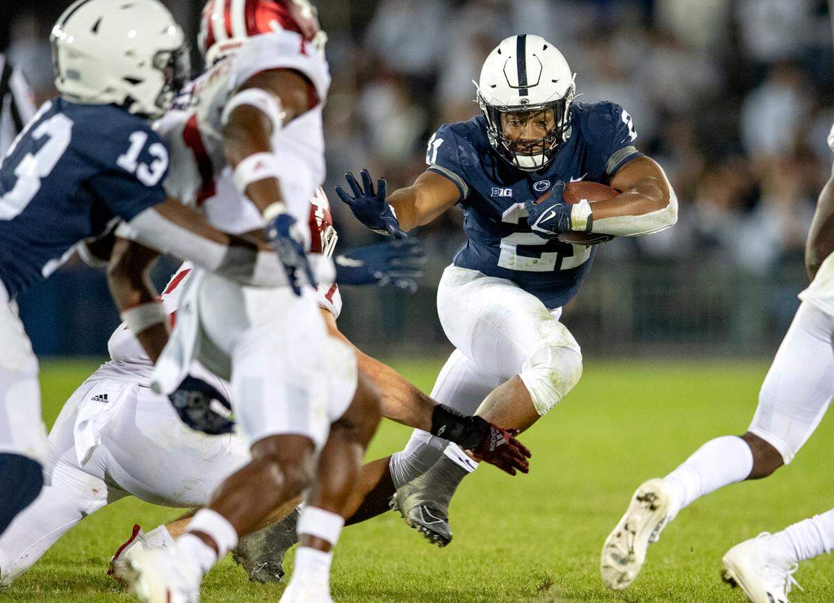 Penn State running back Noah Cain cuts down the field with the ball from Indiana defenders.