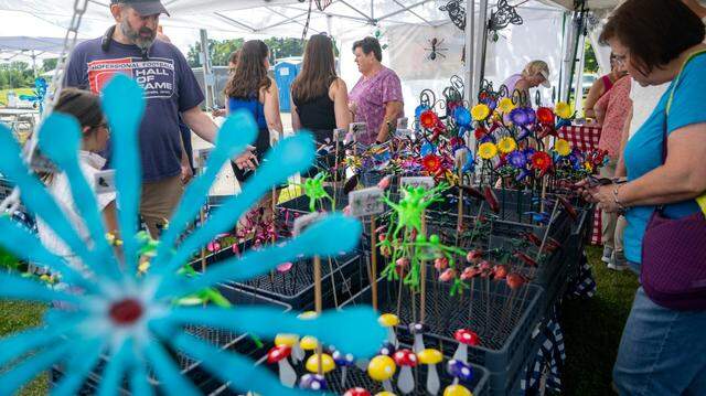Customers browses the Metal Illusions booth at the People’s Choice Festival on Friday, July 14, 2023. All the creations are made from recycled metals and are powder coated to last outside.