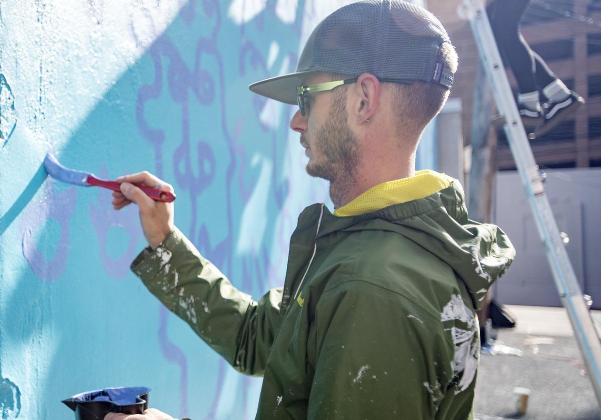 William Snyder III works Tuesday on “Be,” his latest public art project in downtown State College. Snyder will be working on “Be,” located on the back of The State Theatre, over the next few weeks.