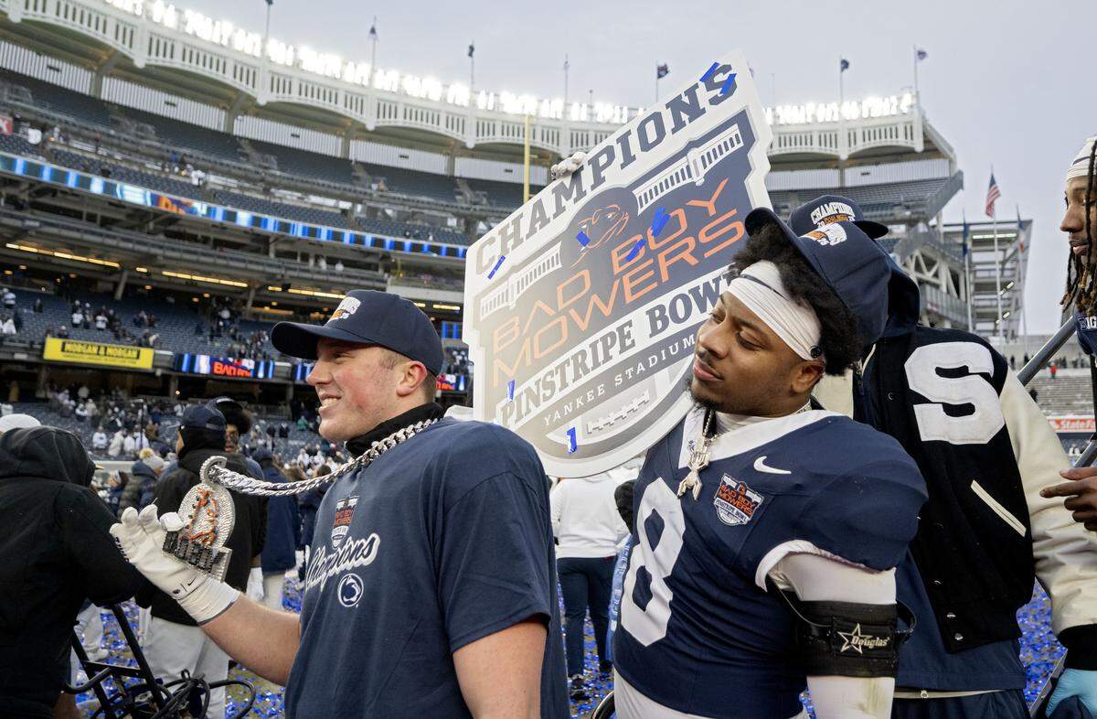 Penn State linebacker DaKaari Nelson holds up a “Champions” sign after the win over Clemson in the Pinstripe Bowl at Yankee Stadium on Saturday, Dec. 27, 2025.  