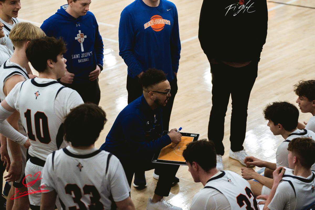 The Saint Joseph’s Catholic Academy team huddles around coach Ethan Khoza
