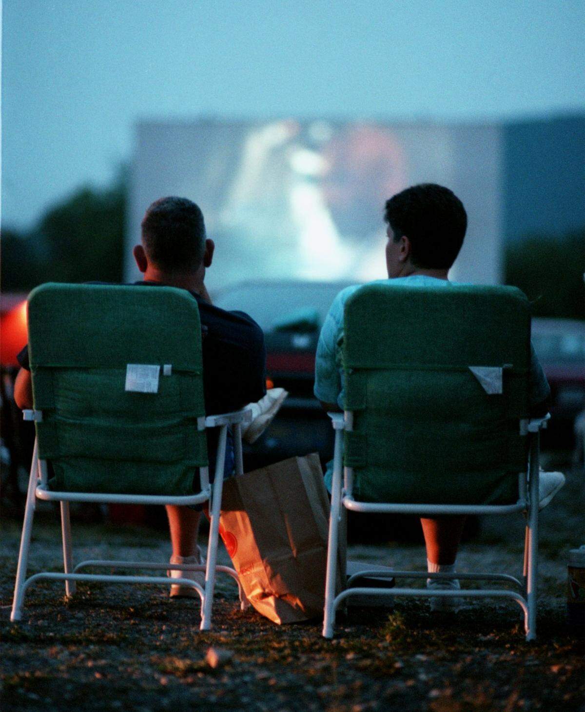 Ken and Marti Roan of Bellefonte sit in lawnchairs while watching a movie at the Starlite Drive-In Theatre on July 31, 1999.