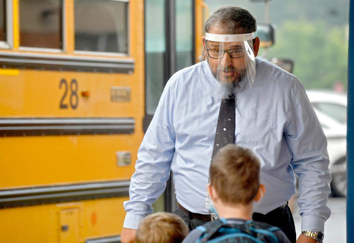 Wingate Elementary Principal James Orichosky keeps his distance and wears a face shield as he excitedly welcomes students back to school on Tuesday, Aug. 25, 2020. Orichosky said teachers and staff are ready to have fun and reconnect with the students.