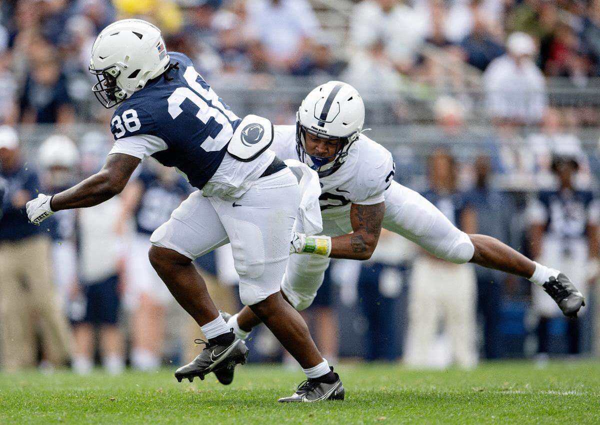 Linebacker Keon Wylie reaches to stop running back Tank Smith during the Penn State Blue-White game on Saturday, April 15, 2023.