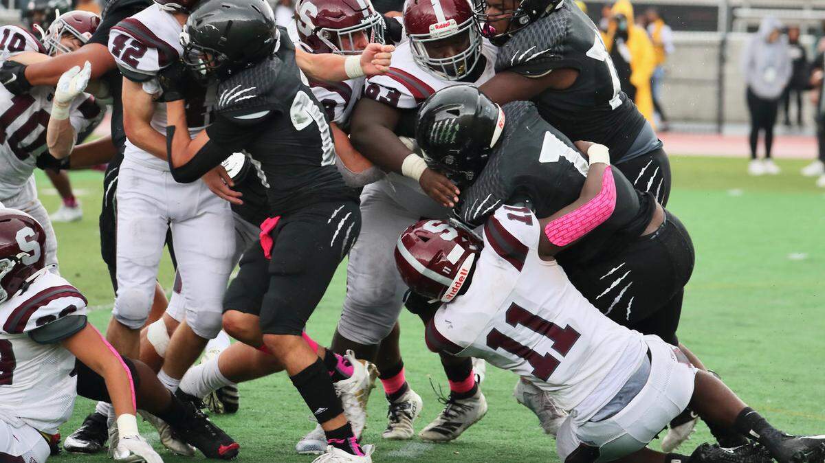 State College’s JW Scott (11) pulls down a Harrisburg player on Saturday, Oct. 23, 2021. State College lost 15-13.