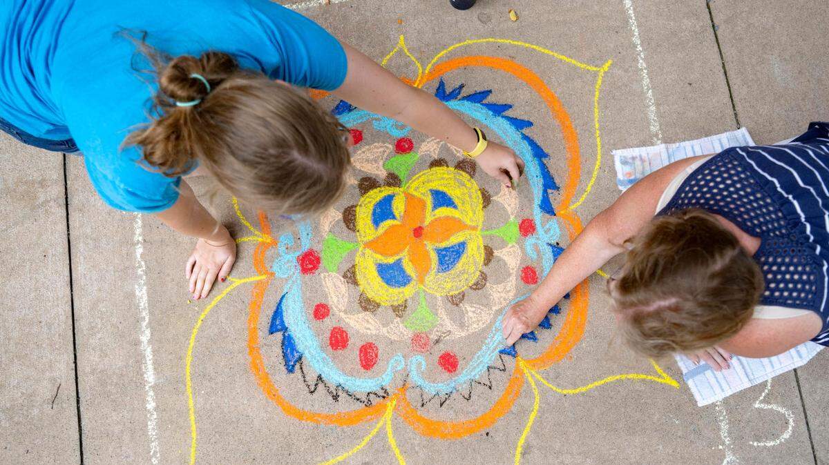 Abbie and Christine Dermota work together Friday on their submission for Chalk the Walk during Friday in the ‘Fonte.