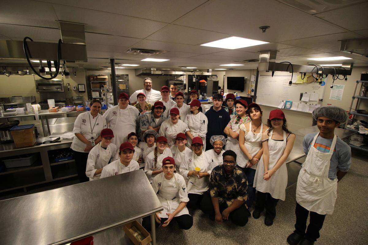 State College Area High School’s culinary arts program gather after preparing a Brazilian-themed dinner.