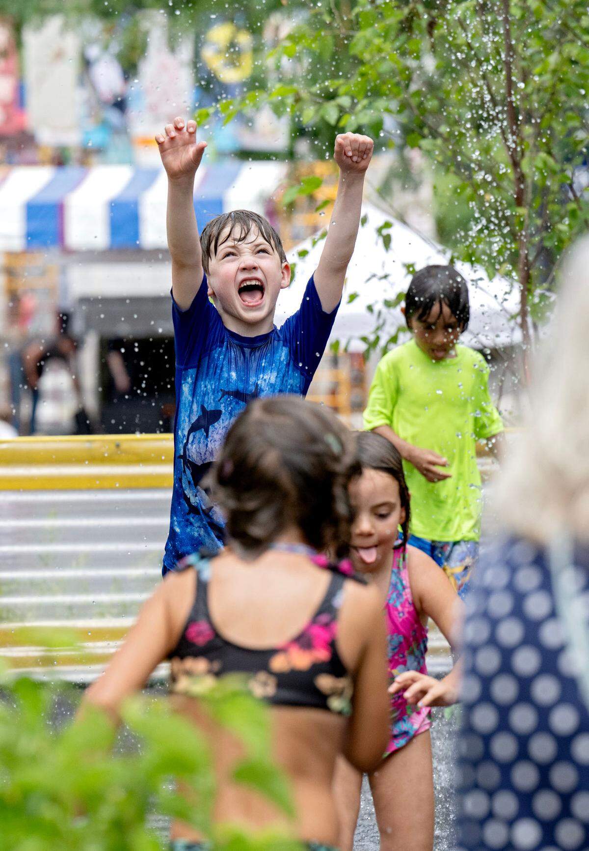 Arthur Moran, 7, runs through the water buckets during the Central Pennsylvania Festival of the Arts Children and Youth sidewalk sale on Wednesday, July 9, 2025.