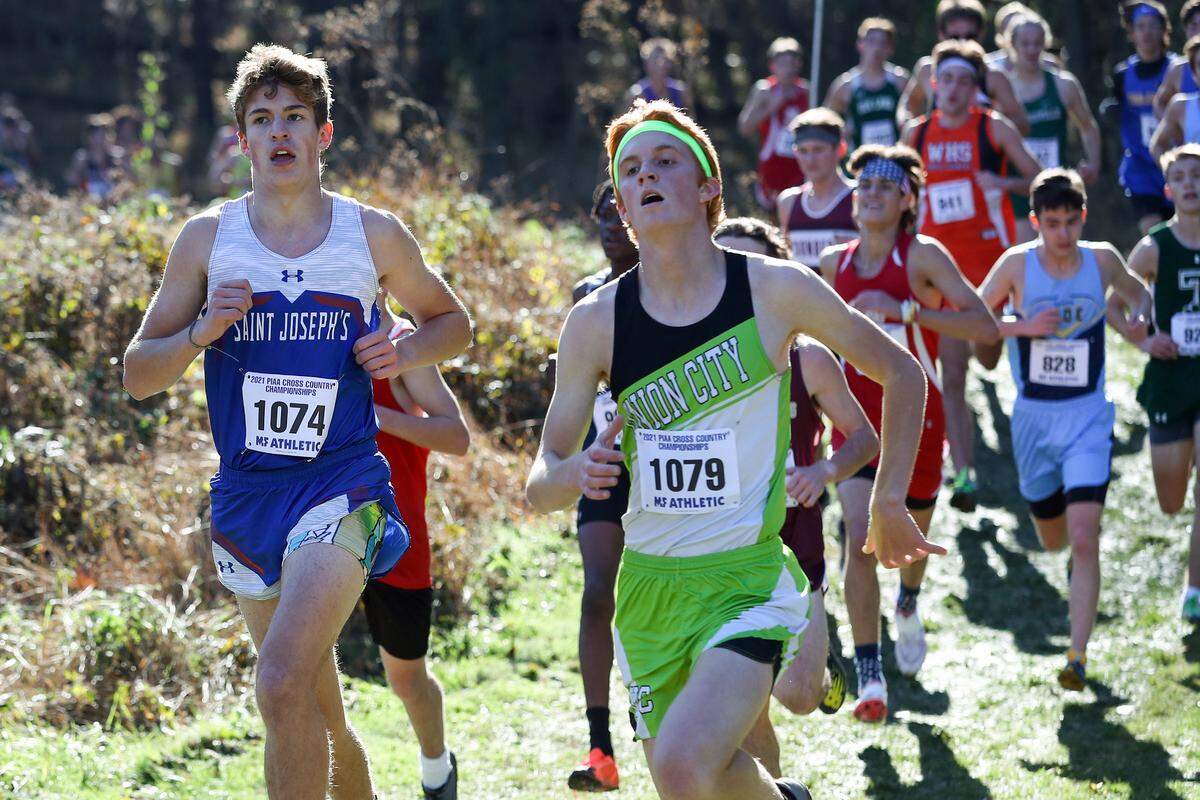 St. Joseph’s Catholic’s Colin Simander, left, competes in the boys 1A race of the PIAA State Cross Country Championships held Saturday at Parkland Cross Country Course in Hershey, PA.Matthew O’Haren/For the Centre Daily Times