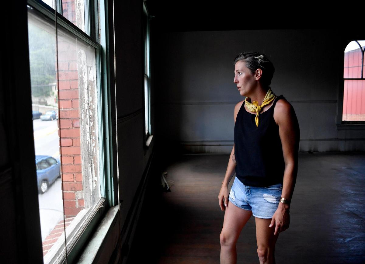 Rebecca Larsen of Gather & Co. Sustainable Catering looks out one of the windows on the second floor of the old firehouse on Howard Street in Bellefonte that she and two others are working to restore.