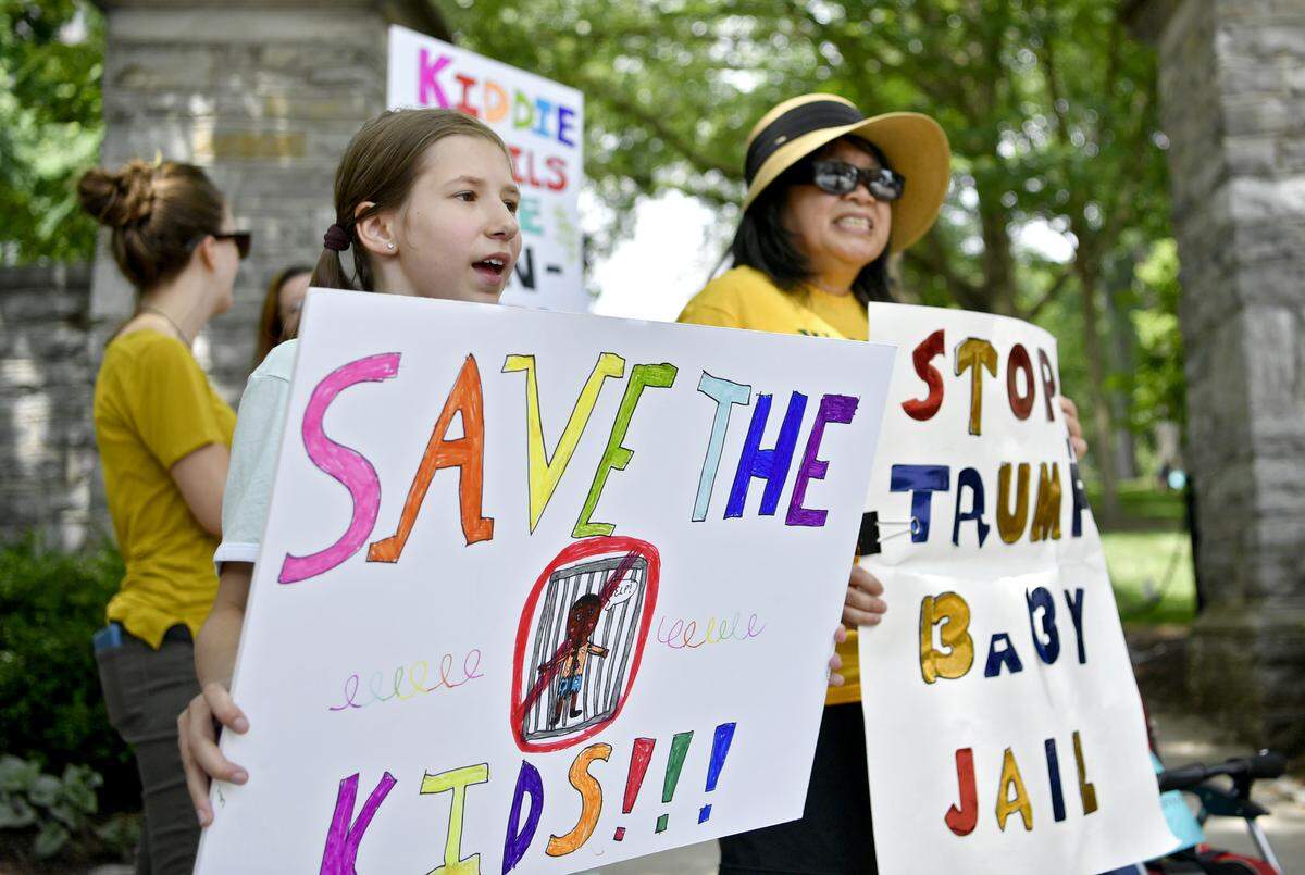 Elliana Miller, 11, holds her handmade sign Tuesday as she gathers with other community members at the #ClosetheCamps rally at the Allen Street Gates.