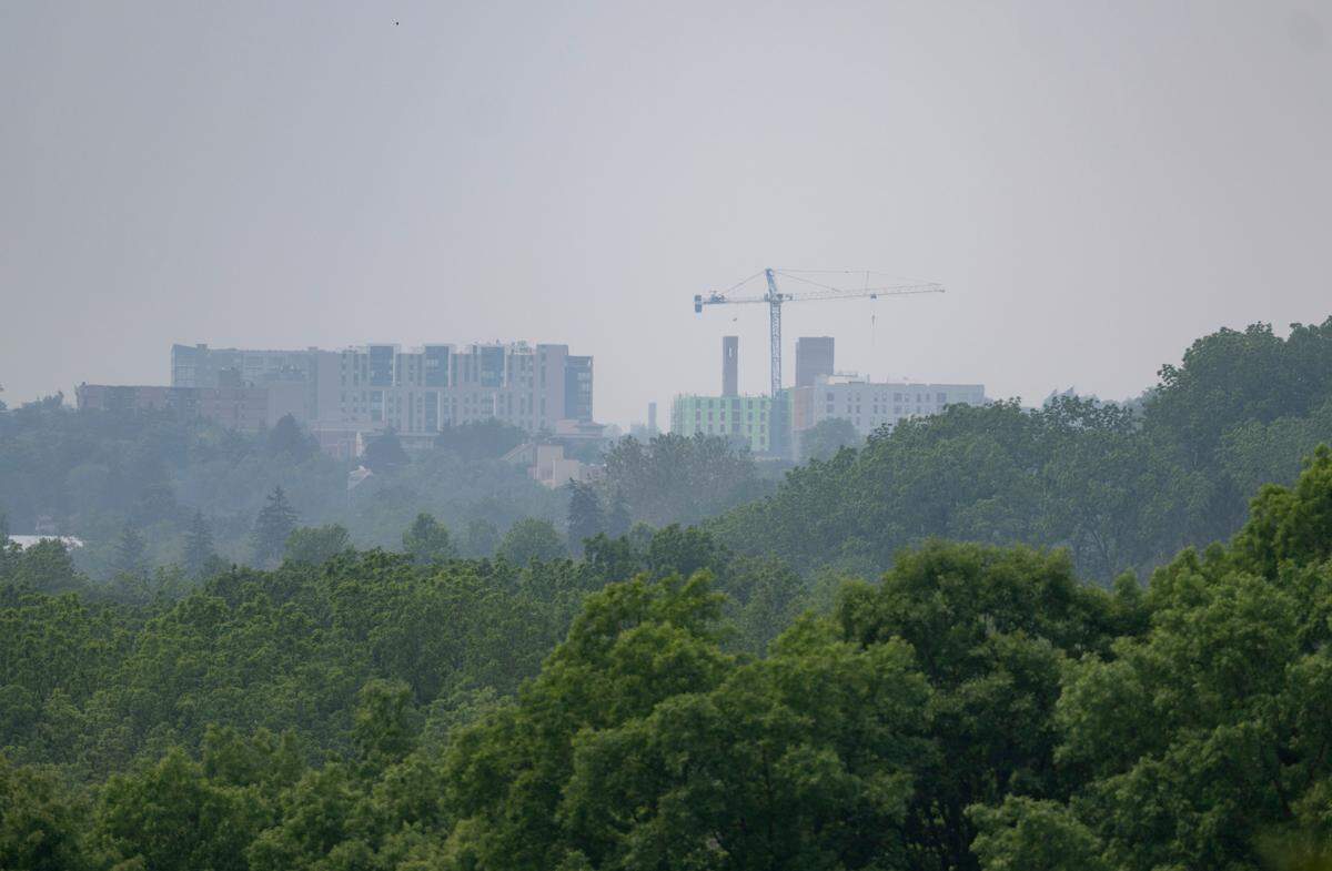 An apartment building and construction crane in downtown State College are seen through smoky skies from Walker Drive on Wednesday, June 7, 2023.