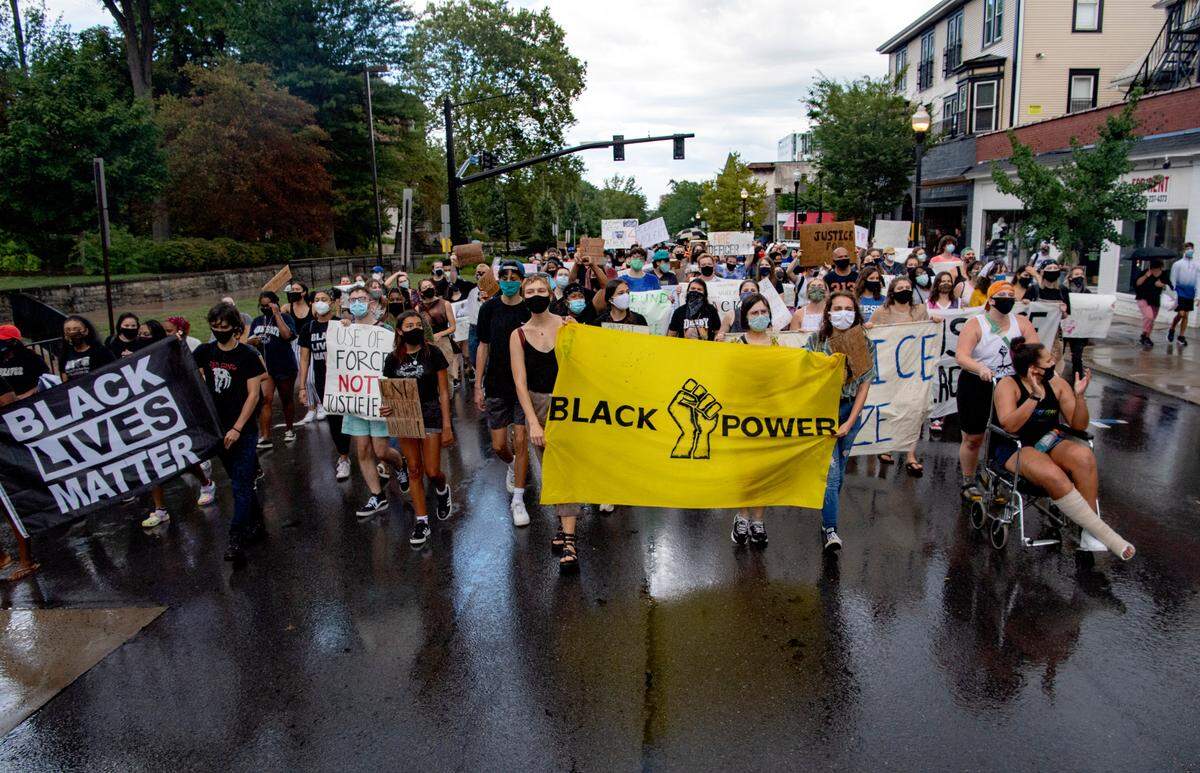 A crowd marches down College Avenue in the rain on Saturday, Aug. 29, 2020. The 3/20 Coalition organizing the march and teach in.