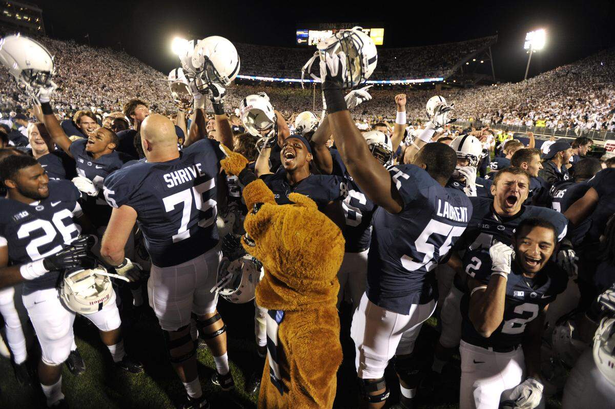 The Nittany Lion mascot celebrates with the Penn State players after the Oct. 12, 2013 win over Michigan during the White Out game. Penn State beat Michigan 43-40 in four overtime periods.
