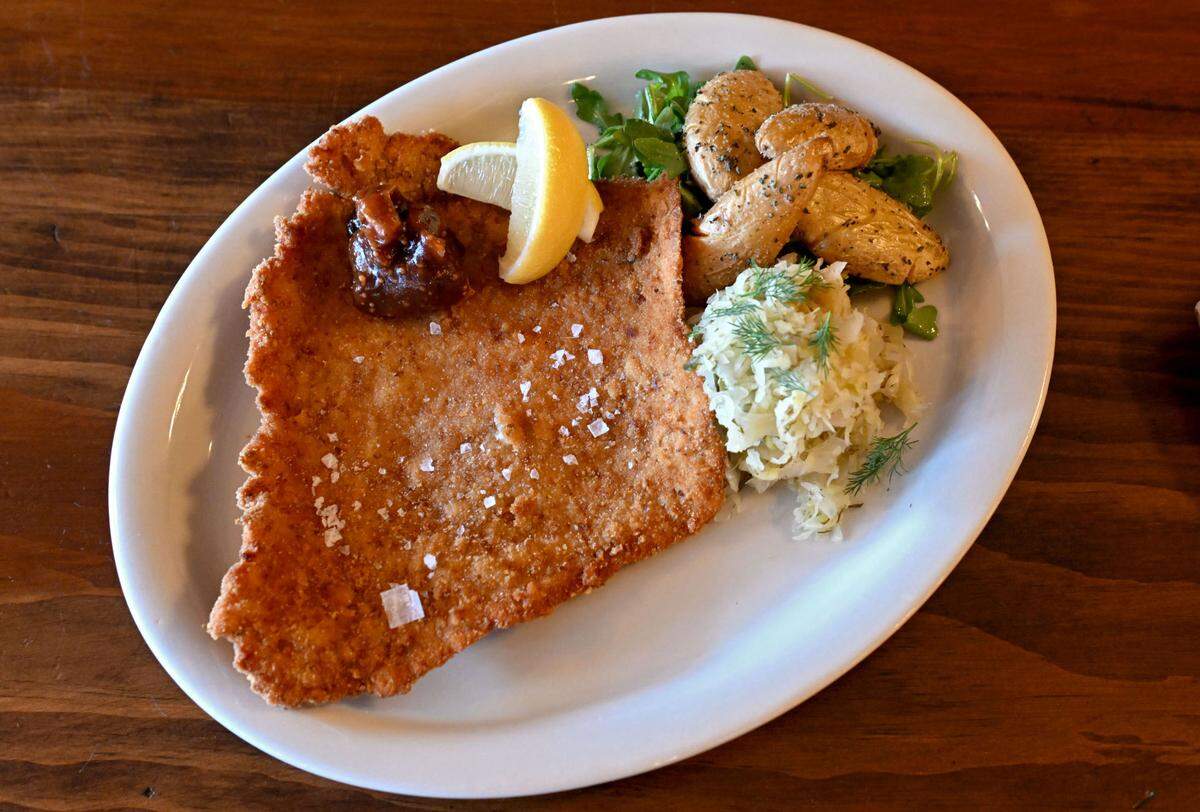 The pretzel-crusted pork schnitzel with dill pickle kraut, fingerling potatoes, apple mostarda and arugula at Pass The Dutchie in Reedsville on Thursday, Dec. 12, 2024.