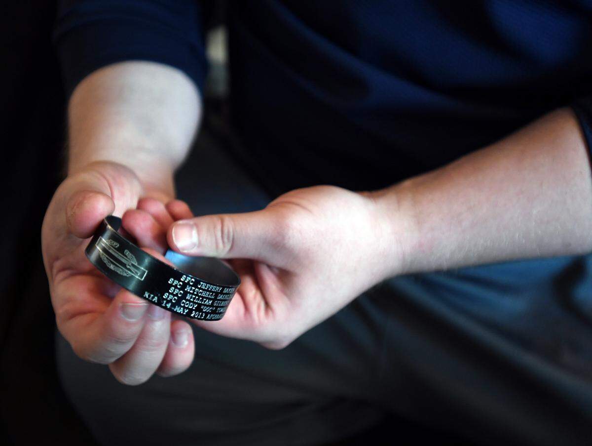 Veteran Adam Hartswick wears a bracelet that commemorates the fallen soldiers he was with five years ago during an IED explosion in Afghanistan.